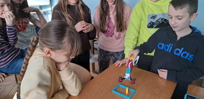Uczniowie pracujący z robotyczną ręką zbudowaną z Lego Education