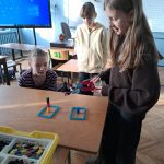 Uczniowie pracujący z robotyczną ręką zbudowaną z Lego Education